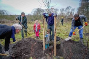 Kinderen en volwassenen planten bomen in de winter